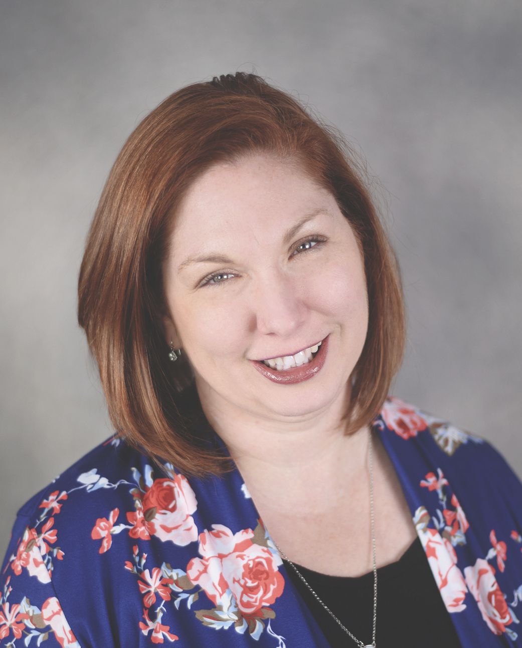 Woman in floral shirt headshot